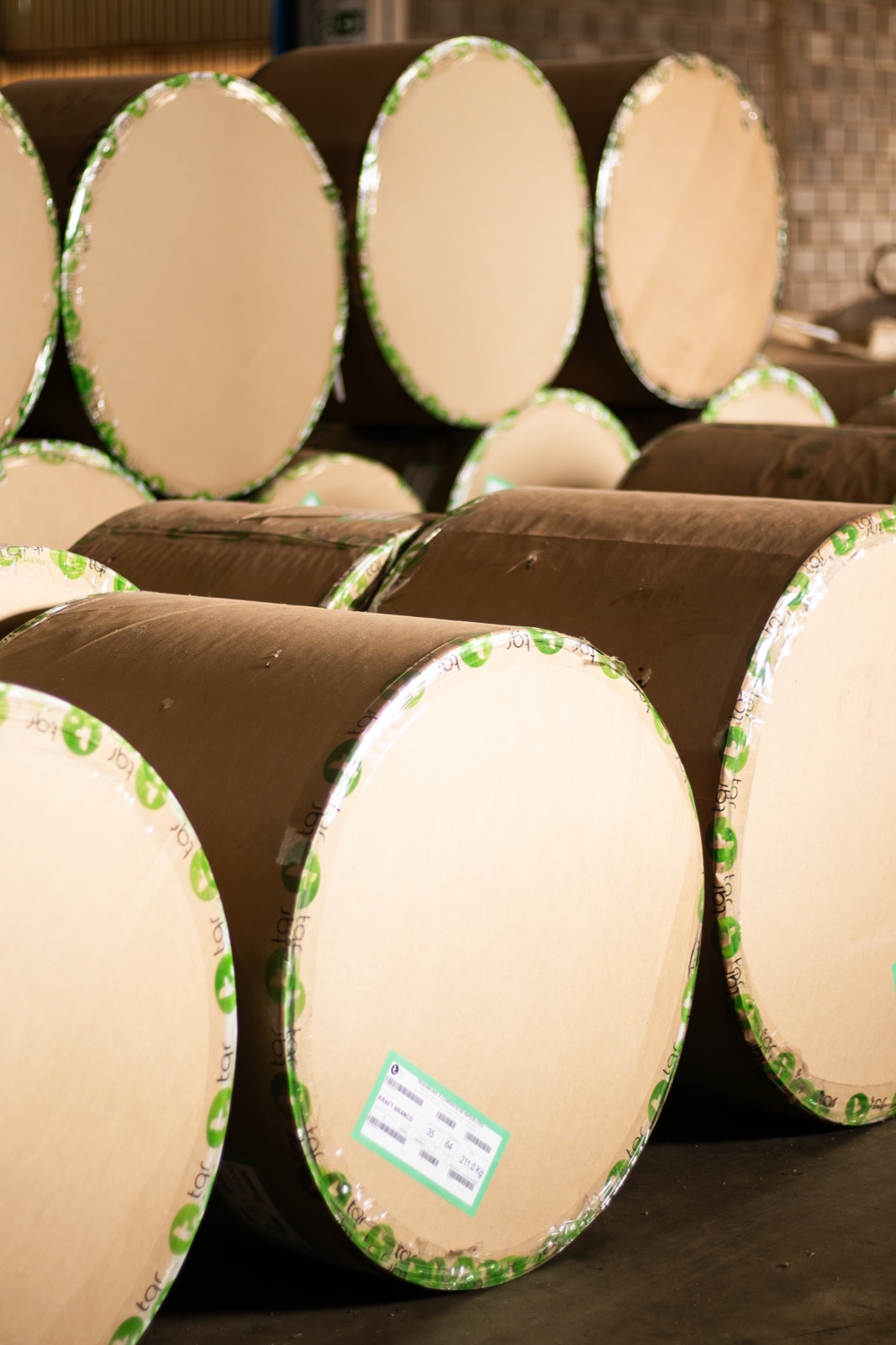 Bobinas de papel kraft branco empilhadas no estoque da fábrica